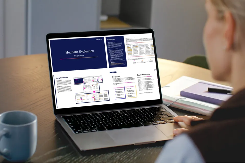 Person viewing Avian's Heuristic Evaluation Framework document on a laptop at a desk